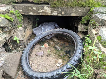 Téléchargez les photos : Tires in a ditch that is dirty with waste rubbish - en image libre de droit