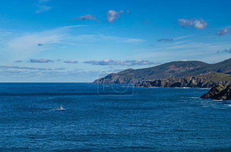 Photo for In the photograph you can see a fishing boat on the high seas with a flock of seagulls flying over it. - Royalty Free Image