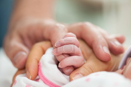 Foto de Primer plano de un recién nacido y sus padres las manos en el hospital el día de su nacimiento. Concepto familiar. Concepto de paternidad - Imagen libre de derechos