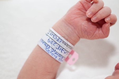 Foto de Primer plano de un brazo y brazalete recién nacido en el hospital el día de su nacimiento - Imagen libre de derechos