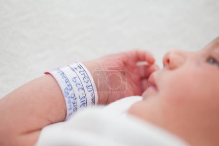 Foto de Primer plano de un brazo y brazalete recién nacido en el hospital el día de su nacimiento - Imagen libre de derechos