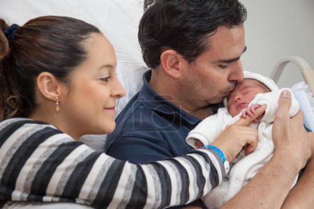 Foto de Joven padre y madre con su bebé recién nacido en el hospital el día de su nacimiento. Concepto familiar. Concepto de paternidad - Imagen libre de derechos