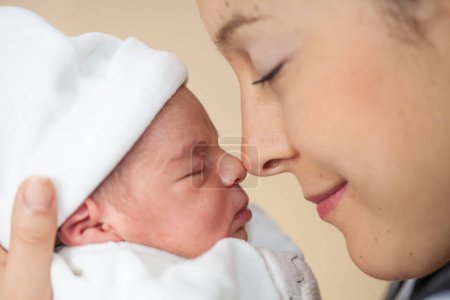 Foto de Joven hermosa madre en el hospital con su niña recién nacida en el día de su nacimiento. Concepto de maternidad - Imagen libre de derechos