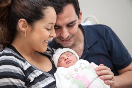 Foto de Joven madre y padre con su bebé recién nacido en el hospital el día de su nacimiento. Concepto familiar. Concepto de paternidad - Imagen libre de derechos