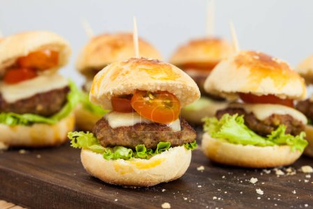 Ready to serve mini hamburgers. Step by step preparation of mini burgers. Homemade mini burgers for children or appetizers. Small hamburgers.