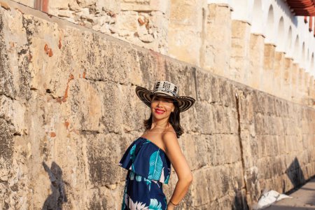 Schöne Frau mit dem traditionellen kolumbianischen Hut namens Sombrero Vueltiao in der historischen Calle de la Ronda der von Mauern umgebenen Stadt Cartagena de Indias