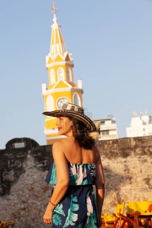 Schöne Frau mit dem traditionellen kolumbianischen Hut namens Sombrero Vueltiao am Uhrturm in den historischen Straßen der von Mauern umgebenen Stadt Cartagena de Indias