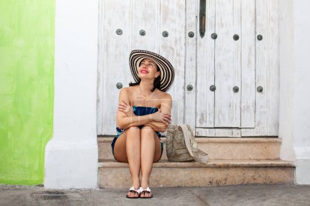 Schöne Frau mit dem traditionellen kolumbianischen Hut namens Sombrero Vueltiao in den historischen Straßen der von Mauern umgebenen Stadt Cartagena de Indias