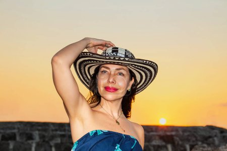 Schöne Frau mit dem traditionellen kolumbianischen Hut namens Sombrero Vueltiao an den historischen Mauern von Cartagena de Indias