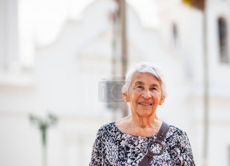 Téléchargez les photos : Femme aînée sur la place centrale de la ville de Guaduas située dans le département de Cundinamarca en Colombie. Mode de vie senior. Concept de voyage senior. - en image libre de droit