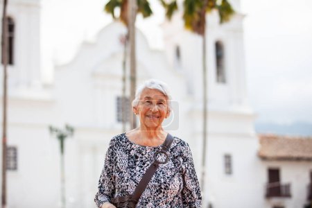 Ältere erwachsene Frau auf dem zentralen Platz der Stadt Guaduas im Departement Cundinamarca in Kolumbien. Senioren-Lebensstil. Seniorenreisekonzept.