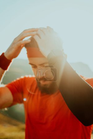 Photo for A determined athlete preparing for the start of training on the top of the mountain at sunrise - Royalty Free Image