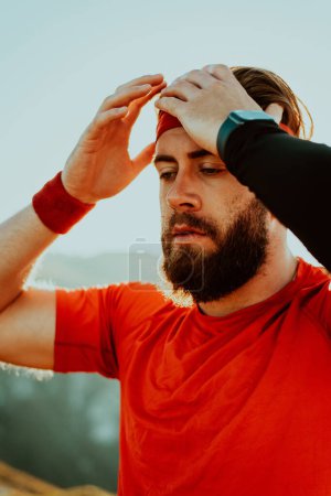 Photo for A determined athlete preparing for the start of training on the top of the mountain at sunrise - Royalty Free Image