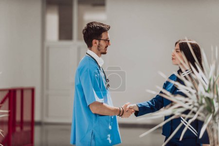 Photo for A doctor and the chief nurse of the medical department exchange a handshake in the hallway of a modern hospital, symbolizing their collaborative and respectful relationship in providing high-quality - Royalty Free Image