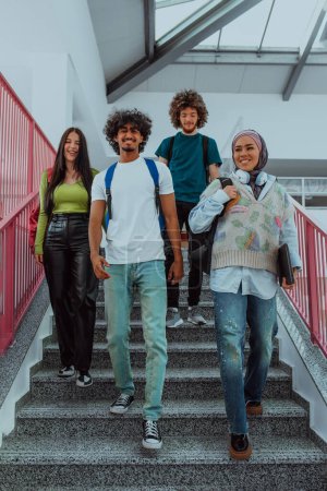 Foto de Un grupo moderno de estudiantes, incluyendo un estudiante afroamericano y un estudiante con un hiyab, caminan juntos en el pasillo de una universidad moderna, reflejando la diversidad, la inclusividad y la búsqueda de - Imagen libre de derechos