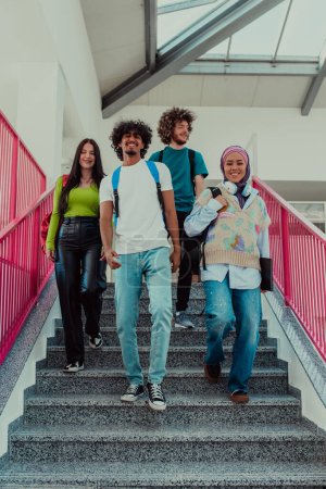 Téléchargez les photos : Un groupe d'étudiants divers, y compris un homme afro-américain et une fille musulmane portant un hijab, marchent ensemble dans les couloirs modernes de l'université, symbolisant l'inclusion et le pouvoir de - en image libre de droit
