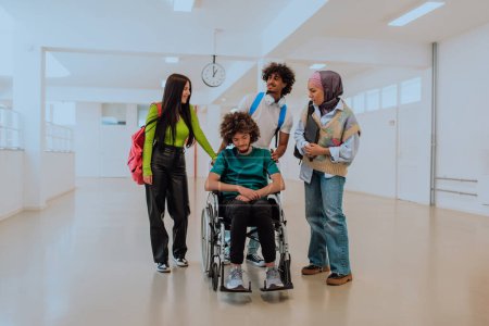 Photo for In a modern university, a diverse group of students, including an African American student and a hijab-wearing woman, walk together in the hallway, accompanied by their wheelchair-bound colleague. - Royalty Free Image