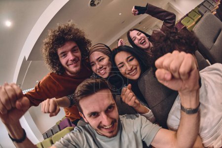 Photo for A diverse group of young people exuberantly celebrates and cheers while watching a soccer match, radiating excitement, unity, and sportsmanship. - Royalty Free Image