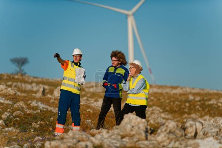 Foto de Un equipo de ingenieros y trabajadores supervisa un proyecto de aerogeneradores en un moderno parque eólico, trabajando juntos para garantizar la generación eficiente de energía renovable. - Imagen libre de derechos