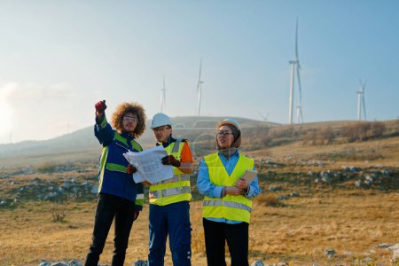 Foto de Un equipo de ingenieros y trabajadores supervisa un proyecto de aerogeneradores en un moderno parque eólico, trabajando juntos para garantizar la generación eficiente de energía renovable. - Imagen libre de derechos
