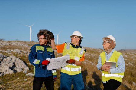 A team of engineers and workers oversees a wind turbine project at a modern wind farm, working together to ensure the efficient generation of renewable energy. 
