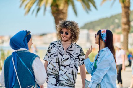 Eine Gruppe von Touristen diskutiert lebhaft, während sie ihre Route für die Erkundung der malerischen Mittelmeerküste planen, voller Spannung und Vorfreude.