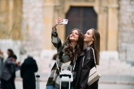 Couple of two female tourists enjoying exploring European cities, concept of tourism and travel, womans with suitcases walking around the city, modern lgbt couple of womans walking around the city. 