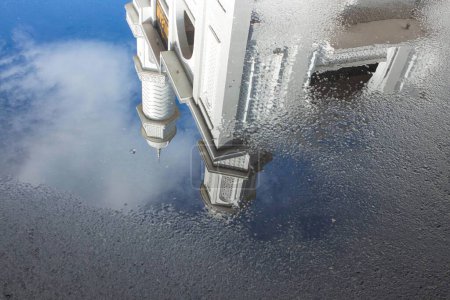 Téléchargez les photos : Vue de la mosquée blanche avec des reflets d'eau sur la route sur un fond bleu ciel - en image libre de droit