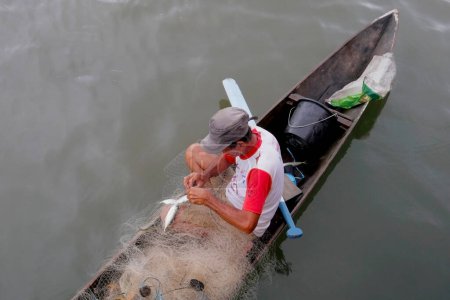 Téléchargez les photos : Homme pêche dans le lac à la plage dans la ville - en image libre de droit
