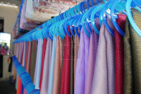 Foto de Colgadores de ropa de colores en una percha en una tienda - Imagen libre de derechos
