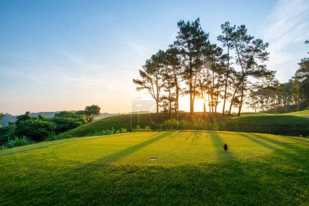 Téléchargez les photos : Parcours de golf le matin avec belle vue sur le soleil - en image libre de droit