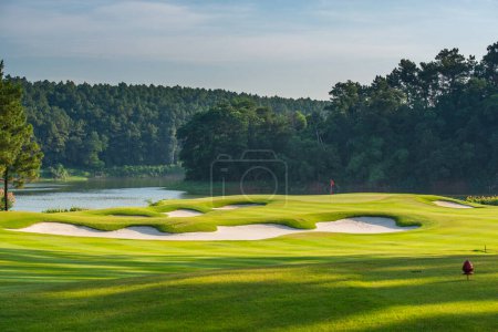 Téléchargez les photos : Terrain de golf avec herbe verte et ciel bleu - en image libre de droit