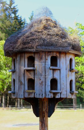 Closeup of an old wooden dovecote standing in the garden. Free-standing empty dovecot