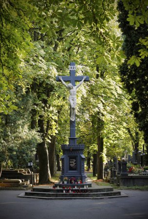 Foto de Estatua de Jesucristo en la cruz con velas en el cementerio. Un gran crucifijo en el cementerio de Vinohrady en Praga. Símbolo de religión y creencia cristiana. - Imagen libre de derechos