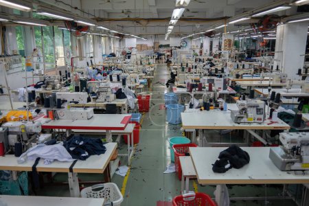 Téléchargez les photos : Ba Ria, VIETNAM - MAR 18 2022: Textile cloth factory working process tailoring workers equipment. This is a sewing machine factory production empty worker. - en image libre de droit