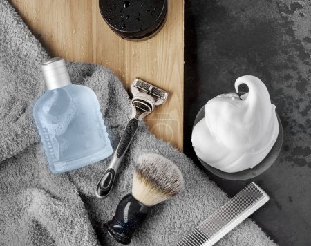 Shaving accessories with shaving foam, razor, shaving brush, lotion on black background. Flat lay, top view