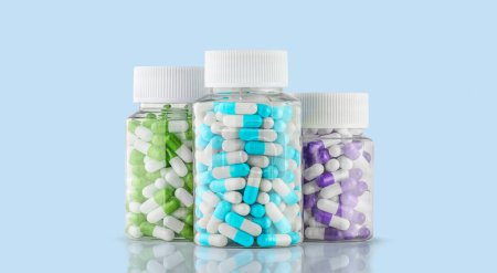 Photo for Bottles transparent with colorful pills capsules on blue background. Nutritional Supplements, Vitamins, multivitamins, Calcium, antibiotics. Health. Immunity - Royalty Free Image
