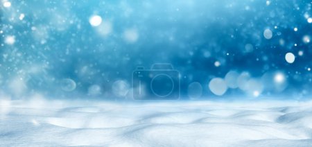 Peaceful winter scene with snowdrifts, falling snowflakes and a blue sky background. Perfect for holiday themes.