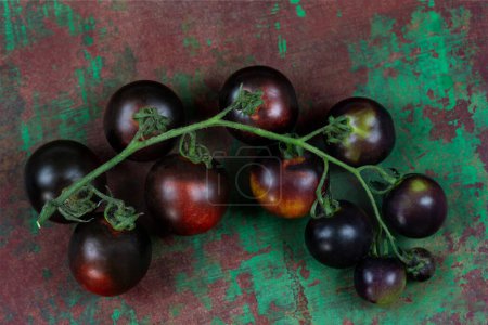 Téléchargez les photos : Grappe de Tomates Yoom sur une vieille planche Marron et vert - en image libre de droit
