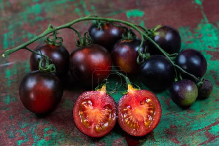 Photo for Yoom tomatoes on an old brown and green board, birds eye view - Royalty Free Image