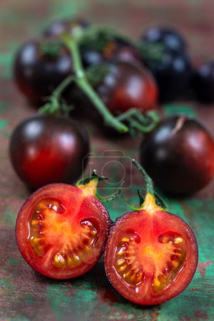 Photo for Yoom tomatoes on an old brown and green board, birds eye view - Royalty Free Image