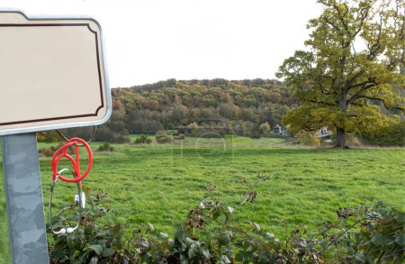 Téléchargez les photos : Stéthoscope accroché au panneau du village devant un paysage rural. - en image libre de droit