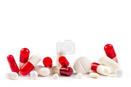 Téléchargez les photos : Capsules et médicaments rouges et blancs en gros plan sur fond blanc recadré. - en image libre de droit