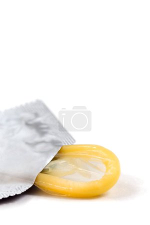 Foto de Condón amarillo en plano vertical sobre fondo blanco - Imagen libre de derechos