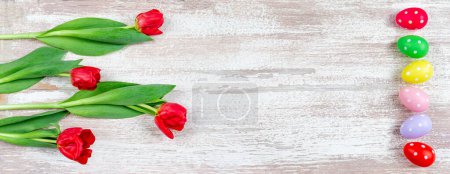 Téléchargez les photos : Œufs de Pâques avec tulipes sur un fond en bois altéré - en image libre de droit