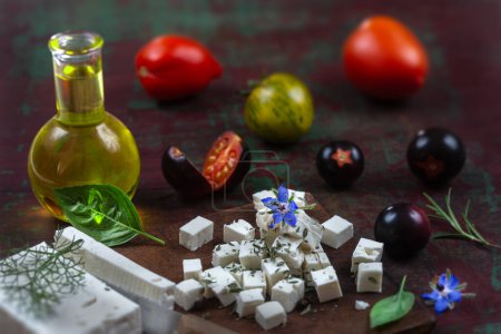 Téléchargez les photos : Bouteille d'huile d'olive et tomates aux feuilles de feta et basilic isolées sur fond brun - en image libre de droit