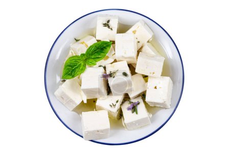 Téléchargez les photos : Cubes de fromage feta isolés sur fond blanc avec chemin de coupe. tas de fromage feta, feuilles de basilic et tomates. - en image libre de droit