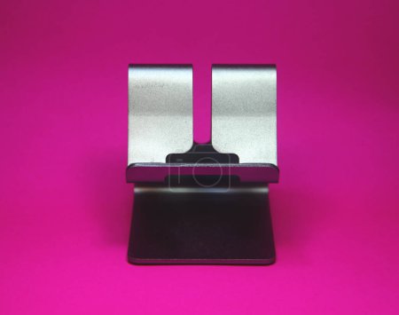 Téléchargez les photos : Small metal steel smartphone mobile phone desk stand display photo isolated on plain background. - en image libre de droit