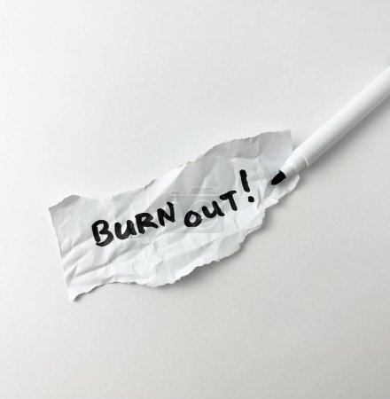Burn out stressé en disant de la fatigue de l'écriture de travail avec marqueur noir isolé sur papier déchiré froissé sur fond blanc.