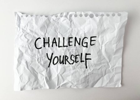 Challenge yourself handwriting with black marker on white crumpled paper texture isolated on white studio background. 
